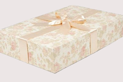Floral-patterned wedding dress box with a ribbon on a white background